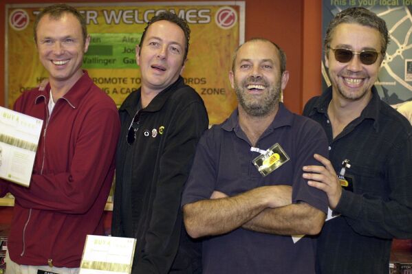 FILE - Karl Wallinger from World Party, right, with Gary Kemp from Spandau Ballet, left, Joe Strummer from The Clash, second left, Keith Allen from Fat Les at Tower Records in Piccadilly, central London, Sept. 14, 2000, where they backed a national organisation called Future Forests. Karl Wallinger, the multi-instrumentalist and solo force behind the band World Party and former member of The Waterboys, has died at age 66. His publicist says Wallinger passed away Sunday March 12, 2024, his publicist said. (Kirsty Wigglesworth/PA via AP)