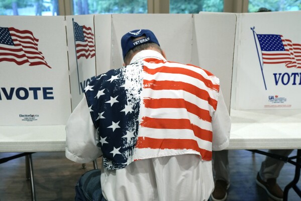 FILE - A patriotic voter sits at a voting kiosk and selects his choices in a party primary in Jackson, Miss., Tuesday, Aug. 8, 2023. Super Tuesday put former President Donald Trump within reach of clinching his third consecutive Republican presidential nomination. But it may be Republican voters in Georgia, Hawaii, Mississippi and Washington who put him over the top. President Joe Biden is also competing in presidential contests that day, but the earliest he can clinch his party's nomination is a week later on March 19. (AP Photo/Rogelio V. Solis, File)