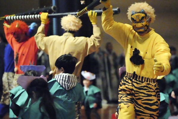 Artists acting as demons dance during the 