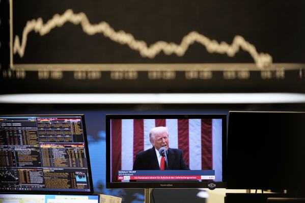 US President Donald Trump appears on a television screen at the stock market in Frankfurt, Germany, Thursday, April 3, 2025. (AP Photo/Michael Probst)