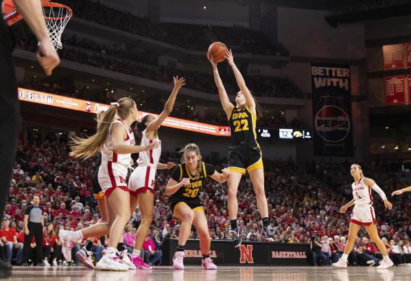 Iowa's Caitlin Clark (22) grabs a rebound alongside teammate Kate Martin, (20) against Nebraska's Logan Nissley, left, and Kendall Coley, second from left, during the first half of an NCAA college basketball game Sunday, Feb. 11, 2024, in Lincoln, Neb. (AP Photo/Rebecca S. Gratz)