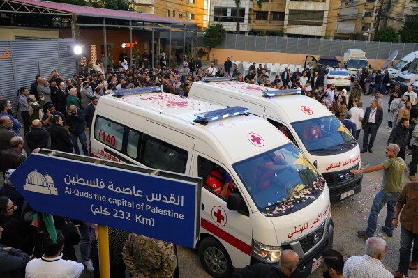 Journalists and family members gather next to Lebanese Red Cross ambulances carrying the bodies of the two slain journalists of pan-Arab TV network Al-Mayadeenm, who were killed by an Israeli strike outside the station's headquarters in Beirut, Lebanon, Tuesday, Nov. 21, 2023. An Israeli strike on southern Lebanon killed Tuesday two journalists reporting for the Beirut-based Al-Mayadeen TV on the violence along the border with Israel, according to the Lebanese information minister and their TV station. (AP Photo/Bilal Hussein)