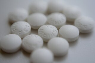 FILE - This Thursday, Aug. 23, 2018 file photo shows an arrangement of aspirin pills in New York. A new study suggests millions of people need to rethink their use of aspirin to prevent a heart attack. If you've already had a heart attack, doctors recommend taking a low-dose aspirin a day to prevent a second one. But if you don't yet have heart disease, doctors now advise routine aspirin can do more harm than good. (AP Photo/Patrick Sison, File)