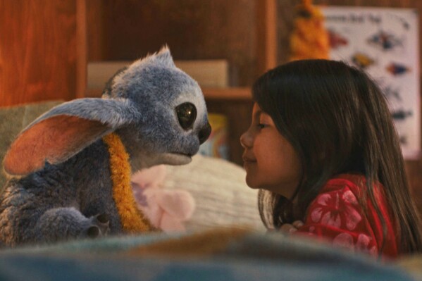 Stitch and Maia Kealoha, as Lilo, in a scene from "Lilo &Stitch." (Disney via AP)