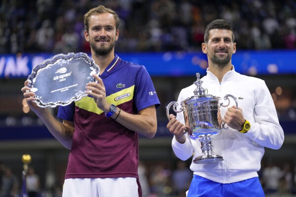 Daniil Medvedev, of Russia, left, holds up the runner-up trophy as Novak Djokovic, of Serbia, holds up the championship trophy after the men's singles final of the U.S. Open tennis championships, Sunday, Sept. 10, 2023, in New York. (AP Photo/Manu Fernandez)