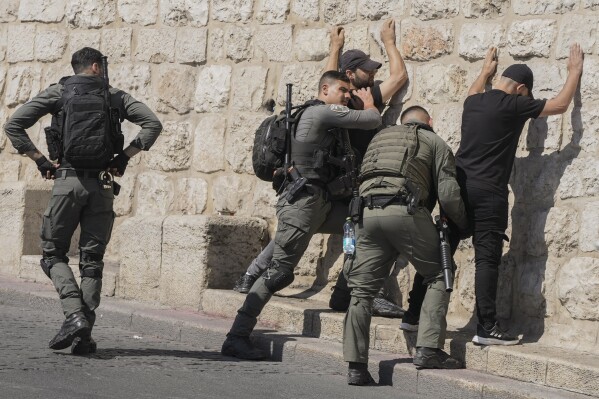 Israeli security forces conduct a security check on Palestinians outside Jerusalem's Old City, Friday, Oct. 13, 2023. At Al-Aqsa Mosque in Jerusalem, Israeli police had been permitting only older men, women and children to the sprawling hilltop compound for prayers, trying to prevent the potential for demonstration as tens of thousands attend on a typical Friday. (AP Photo/Mahmoud Illean)