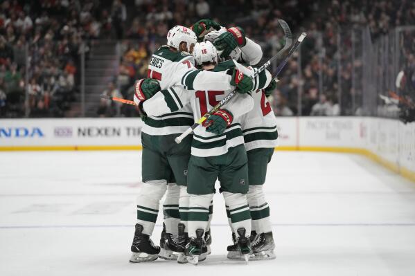 Minnesota Wild players celebrate after center Connor Dewar (26) scored during the second period of an NHL hockey game against the Anaheim Ducks in Anaheim, Calif., Wednesday, Dec. 21, 2022. (AP Photo/Ashley Landis)