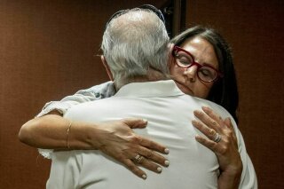 FILE - In this July 11, 2019 file photo, Tanya Gersh, a Montana real estate agent, embraces her father Lloyd Rosenstein following a hearing at the Russell Smith Federal Courthouse in Missoula. Mont. A Montana real estate agent who secured a $14 million judgment against a neo-Nazi website operator for orchestrating an anti-Semitic harassment campaign against her Jewish family is seeking a court order compelling the man to disclose information about his assets and finances. Tanya Gersh's attorneys said in a court filing Friday, Dec. 11, 2020 that The Daily Stormer founder Andrew Anglin hasn't paid any portion of the August 2019 judgment and has ignored their requests for information about his current whereabouts, his operation of the website and other assets. (Ben Allen/The Missoulian via AP, File)