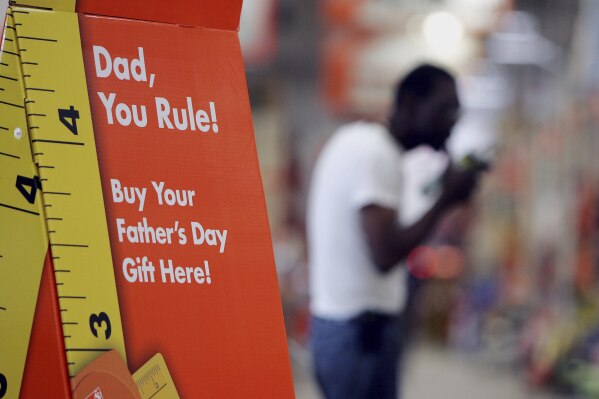 A sign advertises Father's Day gifts as a shopper buys building materials in the background at Atlanta Home Depot store, June 8 , 2006. (AP Photo/John Bazemore, File)