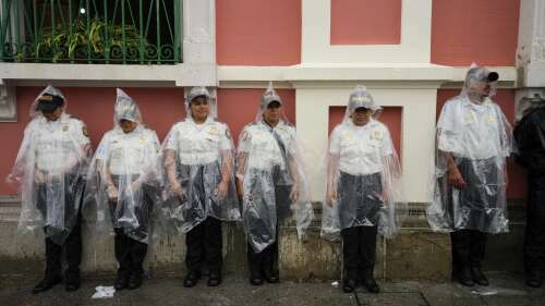 Police stand guard outside the Electoral Court building as demonstrators march to support the electoral process in Guatemala City, on a rainy Saturday, July 8, 2023. Chief Justice Silvia Valdes Quezada issued an order blocking the certification of the results for the first-round presidential June 25th election, late Friday. (AP Photo/Moises Castillo)