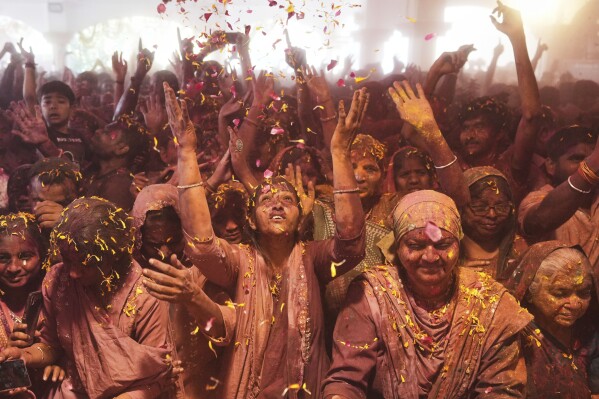 Un grupo de personas celebran el Holi en el templo Lord Jagannath de Ahmedabad, India, el 14 de marzo de 2025. (AP Foto/Ajit Solanki)