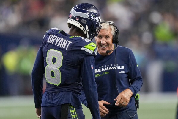 Seattle Seahawks head coach Pete Carroll talks with cornerback Coby Bryant during the second half of a preseason NFL football game against the Dallas Cowboys Saturday, Aug. 19, 2023, in Seattle. (AP Photo/Stephen Brashear)