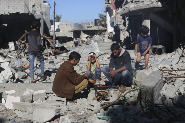 Palestinos cuecen pan junto a sus casas destruidas en Kuza' a, en la Franja de Gaza, durante el cese el fuego temporal entre Hamás e Israel, el miércoles 29 de noviembre de 2023. (AP Foto/Hatem Ali)