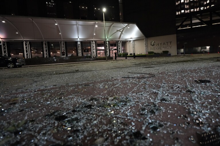 يغطي الزجاج المكسور الشارع خارج فندق حياة ريجنسي في وسط مدينة هيوستن، الخميس 16 مايو 2024، بعد عاصفة رعدية شديدة ضربت هيوستن.  (صورة AP/ديفيد ج. فيليب)