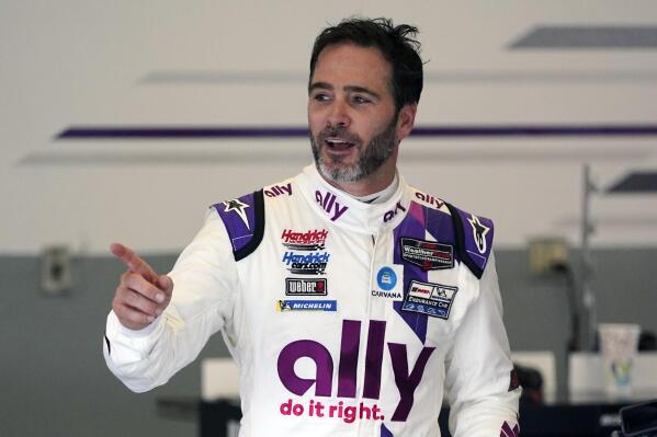 FILE - Jimmie Johnson interacts with crew members in his garage during a practice session for the Rolex 24 hour auto race at Daytona International Speedway, Saturday, Jan. 23, 2021, in Daytona Beach, Fla.  From Italy to Iowa to the simulator and finally the Finger Lakes, there’s been no rest for Jimmie Johnson. He heads this weekend to Watkins Glen for one of this final two scheduled appearances in the IMSA sports car. Then he’ll turn his attention to planning his 2023 schedule — which Johnson hopes includes a spot in the 24 Hours of Le Mans. (AP Photo/John Raoux, File)