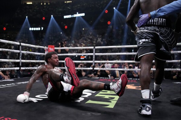 Errol Spence Jr., right, is knocked down by Terence Crawford, right, during their championship boxing match, Saturday, July 29, 2023, in Las Vegas. (AP Photo/John Locher)