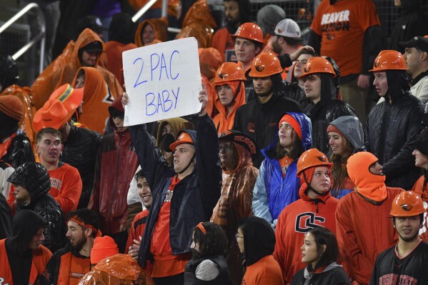 A fan holds up a sign about the Pac-12 Conference during the second half of an NCAA college football game between Oregon State and Washington Saturday, Nov. 18, 2023, in Corvallis, Ore. (AP Photo/Mark Ylen)