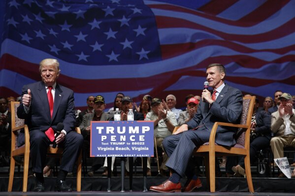 FILE - Then-presidential candidate Donald Trump gives a thumbs up as he speaks with retired Lt. Gen. Michael Flynn during a town hall, Tuesday, Sept. 6, 2016, in Virginia Beach, Va. President Donald Trump has pardoned Michael Flynn, taking direct aim in the final days of his administration at a Russia investigation that he has long insisted was motivated by political bias. Trump announced the pardon on Wednesday, Nov. 25, 2020 calling it his “Great Honor.” (AP Photo/Evan Vucci, file)