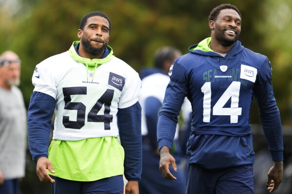 Seattle Seahawks linebacker Bobby Wagner (54) and wide receiver DK Metcalf (14) walk on the field during the NFL football team's training camp, Wednesday, Aug. 9, 2023, in Renton, Wash. (AP Photo/Lindsey Wasson)