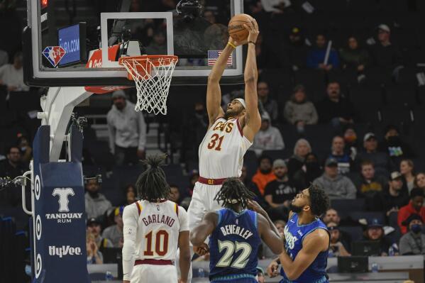 Cleveland Cavaliers center Jarrett Allen goes up for a dunk as Cavaliers guard Darius Garland (10) and Minnesota Timberwolves guard Patrick Beverley (22) and center Karl-Anthony Towns watch during the first half of an NBA basketball game Friday, Dec. 10, 2021, in Minneapolis. (AP Photo/Craig Lassig)