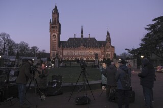 Periodistas trabajan ante la Corte Internacional de Justicia antes de una vista en La Haya, Holanda, el jueves 11 de enero de 2024. (AP Foto/Patrick Post)