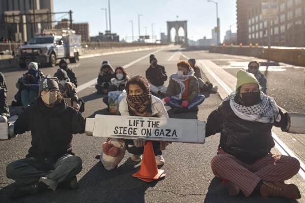 Protestors block Brooklyn Bridge during a pro-Palestinian demonstration demanding a cease-fire in the Israel-Palestinian conflict on Monday, Jan. 8, 2024, in New York. (AP Photo/Andres Kudacki)