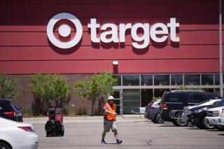 FILE - A worker collects shopping carts in the parking lot of a Target store on June 9, 2021, in Highlands Ranch, Colo. Target on Wednesday May 17, 2023 reported another quarterly profit decline and issued a cautious sales and profit outlook for the current period. (AP Photo/David Zalubowski, File)