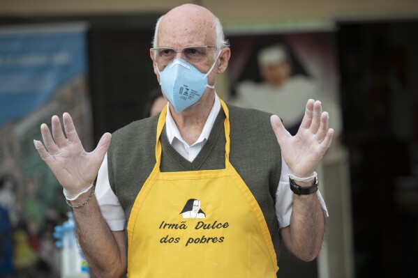 Priest Julio Lancellotti works on a food line for the homeless, in Sao Paulo, Brazil, April 3, 2020. The archdiocese of Sao Paulo said Wednesday, Jan. 3, 2024, it is shocked by a decision of the city’s council to open way for an investigation on Lancellotti, who leads an initiative to feed and shelter the homeless, chiefly in the crime-ridden region known as Crackland. (AP Photo/Andre Penner)