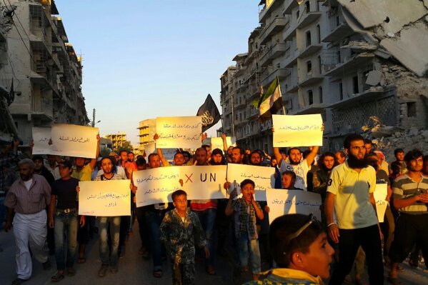 Activists in Syria’s besieged Aleppo protest against the United Nations for what they say is its failure to lift the siege off their rebel-held area, Tuesday, Sept. 13, 2016.  Dozens of protesters marched in al-Shaar neighborhood heading toward the Castello road, the area from which aid is expected to be delivered. “Hunger better than humiliation,” one banner read. “X the UN,” another read. (Modar Shekho via AP)