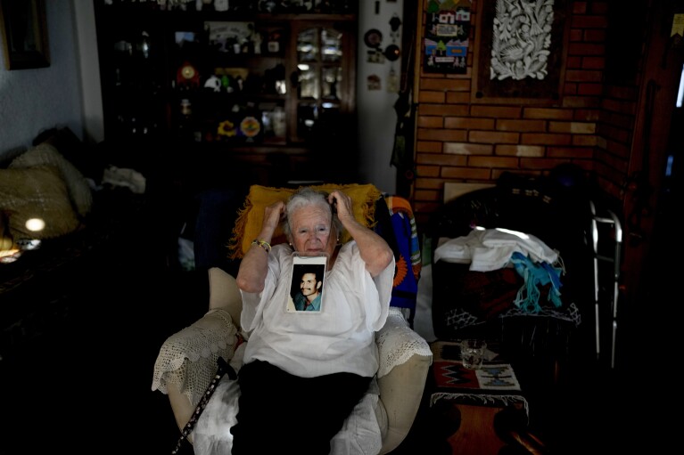 Nora Cortinas, 94, wears a photo of her disappeared son Gustavo as she poses for a portrait on the outskirts of Buenos Aires, Argentina, Monday, Jan. 29, 2024. Cortinas became one of many mothers whose children were kidnapped by the state when her son disappeared on April 15, 1977, giving birth to what is today’s human rights organization, the Mothers of Plaza de Mayo. (AP Photo/Natacha Pisarenko)