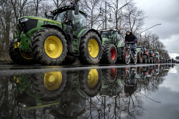 Farmers place their tractors at the government district in Berlin, Germany, Monday, Jan. 15, 2024 ahead of a demonstration. This week began and ended with the long road in front of Berlin’s landmark Brandenburg Gate thronged by heavy vehicles tooting their horns in protest — farmers on Monday Jan. 15 and truckers on Friday Jan. 19, 2024. Such demonstrations underline deep frustration in Germany with Chancellor Olaf Scholz’s government, which came to power just over two years ago with a progressive, modernizing agenda but has come to be viewed by many as dysfunctional and incapable. (AP Photo/Ebrahim Noroozi, File)