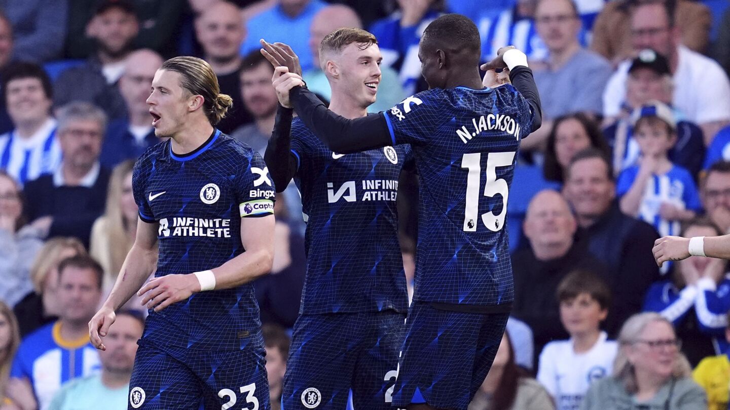Nkunku inflates a blue balloon to celebrate a goal in Chelsea’s 2-1 win at Brighton in the Premier League