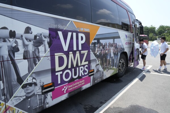 A banner advertising DMZ tour is attached at a tourist bus at the Imjingak Pavilion in Paju, South Korea, near the border with North Korea, Wednesday, July 19, 2023. North Korea was silent about the highly unusual entry of an American soldier across the Koreas' heavily fortified border although it test-fired short-range missiles Wednesday in its latest weapons display. (AP Photo/Ahn Young-joon)