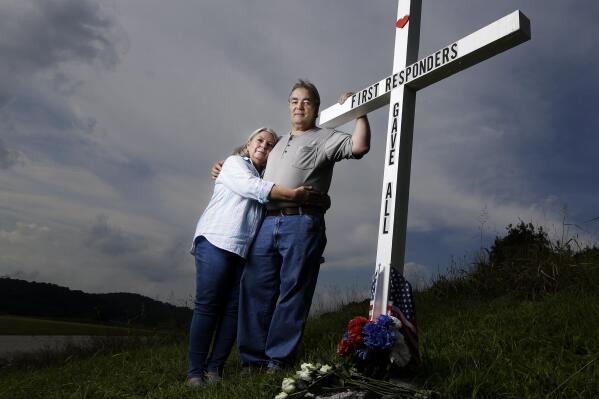 FILE - In this Aug. 6, 2019, photo, Ansol and Janie Clark pose at a memorial Ansol Clark constructed near the Kingston Fossil Plant in Kingston, Tenn. The Tennessee Valley Authority was responsible for a massive coal ash spill at the plant in 2008 that covered a community and fouled rivers. The couple says the memorial is for the workers who have come down with illnesses, some fatal, including cancers of the lung, brain, blood and skin and chronic obstructive pulmonary disease. Ansol Clark who drove a fuel truck for four years at the cleanup site, and suffered from a rare blood cancer, has also died now. (AP Photo/Mark Humphrey, File)