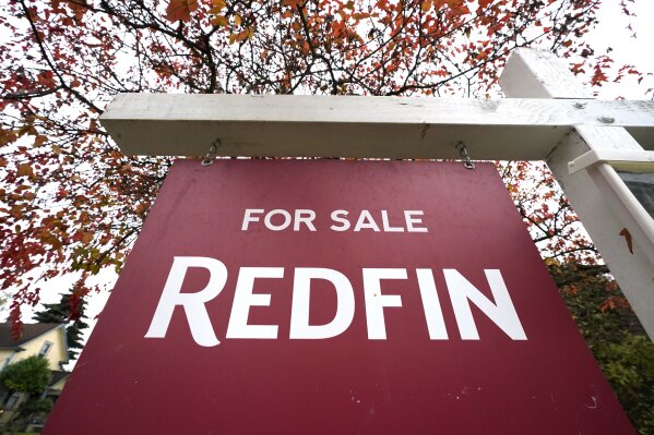 A Redfin "for sale" sign stands in front of a house Wednesday, Oct. 28, 2020, in Seattle. Several fair housing organizations accused Redfin of systematic racial discrimination in a lawsuit Thursday, saying the online real estate broker offers fewer services to homebuyers and sellers in minority communities, a type of "digital redlining" that has depressed home values and exacerbated historic injustice in the housing market. (AP Photo/Elaine Thompson)