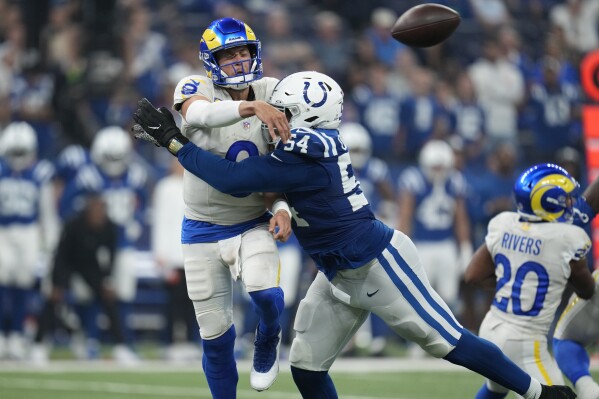 Los Angeles Rams quarterback Matthew Stafford throws the ball as he is hit by Indianapolis Colts defensive end Dayo Odeyingbo during the second half of an NFL football game, Sunday, Oct. 1, 2023, in Indianapolis. (AP Photo/Michael Conroy)