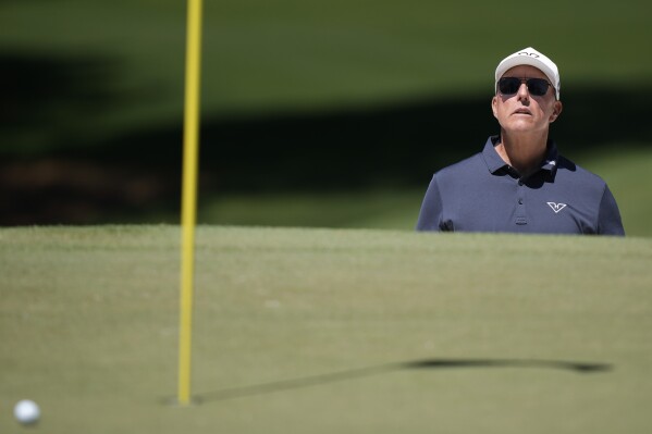Phil Mickelson watches his bunker shot on the seventh hole during third round at the Masters golf tournament at Augusta National Golf Club Saturday, April 13, 2024, in Augusta, Ga. (AP Photo/Charlie Riedel)
