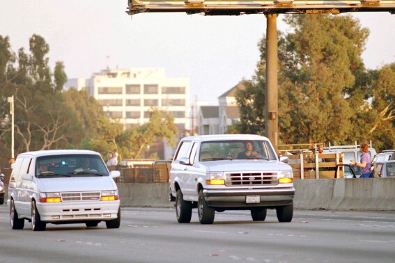 FILE - Al Cowlings, with O.J. Simpson hiding, drives a white Ford Bronco as they lead police on a two-county chase along the northbound 405 Freeway towards Simpson's home, June 17, 1994, in Los Angeles. Simpson, the decorated football superstar and Hollywood actor who was acquitted of charges he killed his former wife and her friend but later found liable in a separate civil trial, has died. He was 76. (AP Photo/Lois Bernstein, File)