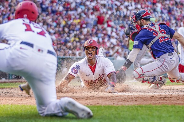 Washington Nationals' Jeter Downs slides across home plate to score on a double by Washington Nationals' Joey Meneses to take the lead during the fifth inning of a baseball game against the Boston Red Sox at Nationals Park, Thursday, Aug. 17, 2023, in Washington. (AP Photo/Andrew Harnik)