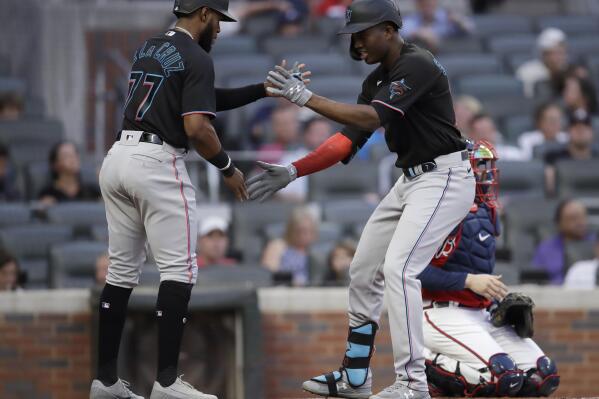 Miami Marlins' Jesus Sanchez, right, celebrates with Bryan De La Cruz (77) after hitting a two-run home run off Atlanta Braves pitcher Ian Anderson during the first inning of a baseball game Friday, Sept. 10, 2021, in Atlanta. (AP Photo/Ben Margot)