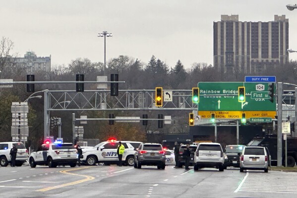 Law enforcement personnel block off the entrance to the Rainbow Bridge border crossing, Wednesday, Nov. 22, 2023, in Niagara Falls, N.Y. The border crossing between the U.S. and Canada has been closed after a vehicle exploded at a checkpoint on a bridge near Niagara Falls. The FBI's field office in Buffalo said in a statement that it was investigating the explosion on the Rainbow Bridge, which connects the two countries across the Niagara River. (AP Photo/Carolyn Thompson)