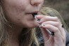 A high school student uses a vaping device near a school campus in Cambridge, Mass., April 11, 2018. (AP Photo/Steven Senne, File)