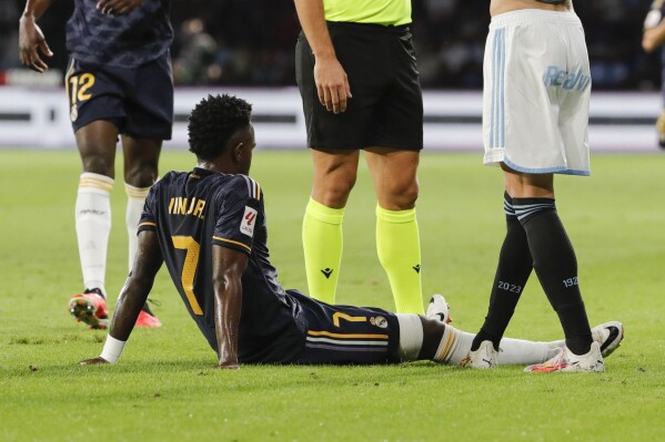 Real Madrid's Vinicius Junior sits on the pitch after being injured during the Spanish La Liga soccer match between Celta Vigo and Real Madrid at the Balaidos stadium in Vigo, Spain, Friday, Aug. 25, 2023. (AP Photo/Lalo R. Villar)