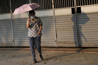 A woman holds an umbrella to shelter from the sun in Bangkok, Thailand, Saturday, April 22, 2023. The authorities warned residents across Thailand to avoid outdoor activities due to extreme heat over the weekend. (AP Photo/Sakchai Lalit)