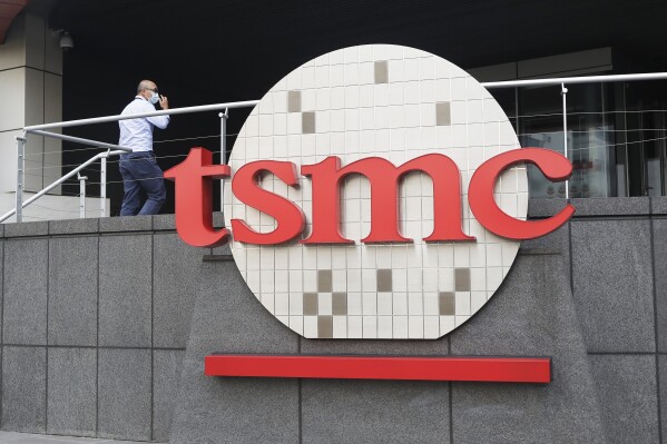 FILE - A person walks into the Taiwan Semiconductor Manufacturing Co., Ltd. (TSMC) headquarters in Hsinchu, Taiwan on Oct. 20, 2021. Beijing's threats to use force to claim self-governed Taiwan aren't just about missiles and warships. Hard economic realities will be at play as voters head to the polls on Saturday, though the relationship is complicated. (AP Photo/Chiang Ying-ying, File)
