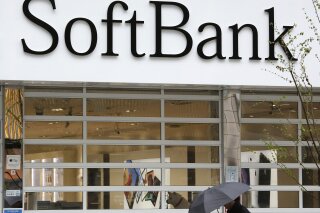 In this April 9, 2019, photo, a man walks past in front of a SoftBank shop in Tokyo. Japanese internet company SoftBank Group Corp. set up its second investment fund for technology such as artificial intelligence. Tokyo-based SoftBank said Friday, July 26, 2019 its $108 billion Vision Fund 2 fund includes $38 billion from SoftBank, and the rest from Apple, FoxConn Technology Group, Microsoft Corp., Japanese banks and other companies. (AP Photo/Shuji Kajiyama)