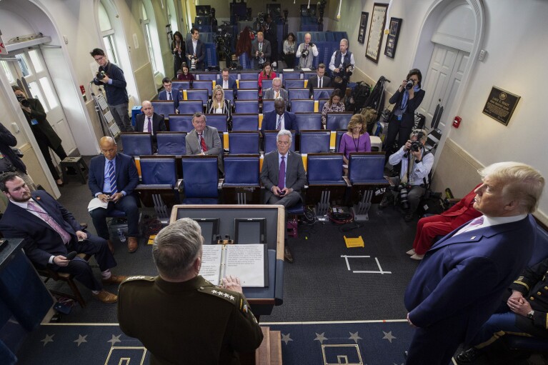 FILE - Joint Chiefs Chairman Gen. Mark Milley, left, speaks as President Donald Trump listens, during a briefing about the coronavirus in the James Brady Press Briefing Room of the White House, Wednesday, April 1, 2020, in Washington. (AP Photo/Alex Brandon, File)