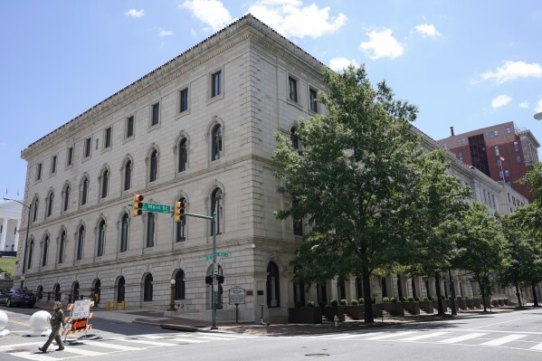 FILE - A pedestrian passes by the 4th Circuit Court of Appeals Courthouse, June 16, 2021, on Main Street in Richmond, Va. The federal appeals court on Tuesday, Nov. 21, 2023, struck down Maryland’s handgun licensing law, finding that its requirements, which include submitting fingerprints for a background check and taking a four-hour firearms safety course, are unconstitutionally restrictive. (AP Photo/Steve Helber, File)