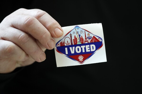 A voter displays an "I Voted" sticker during the first day of early voting at the Galleria at Sunset mall Saturday, Oct. 19, 2024, in Henderson, Nev. (Steve Marcus/Las Vegas Sun via AP)