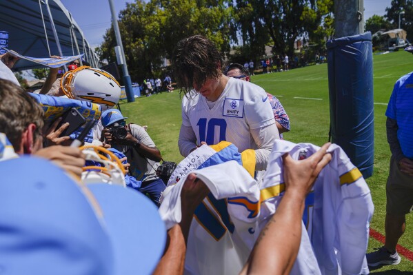 Los Angeles Chargers quarterback Justin Herbert signs autographs during the NFL football team's training camp, Wednesday, July 26, 2023, in Costa Mesa, Calif. (AP Photo/Ryan Sun)